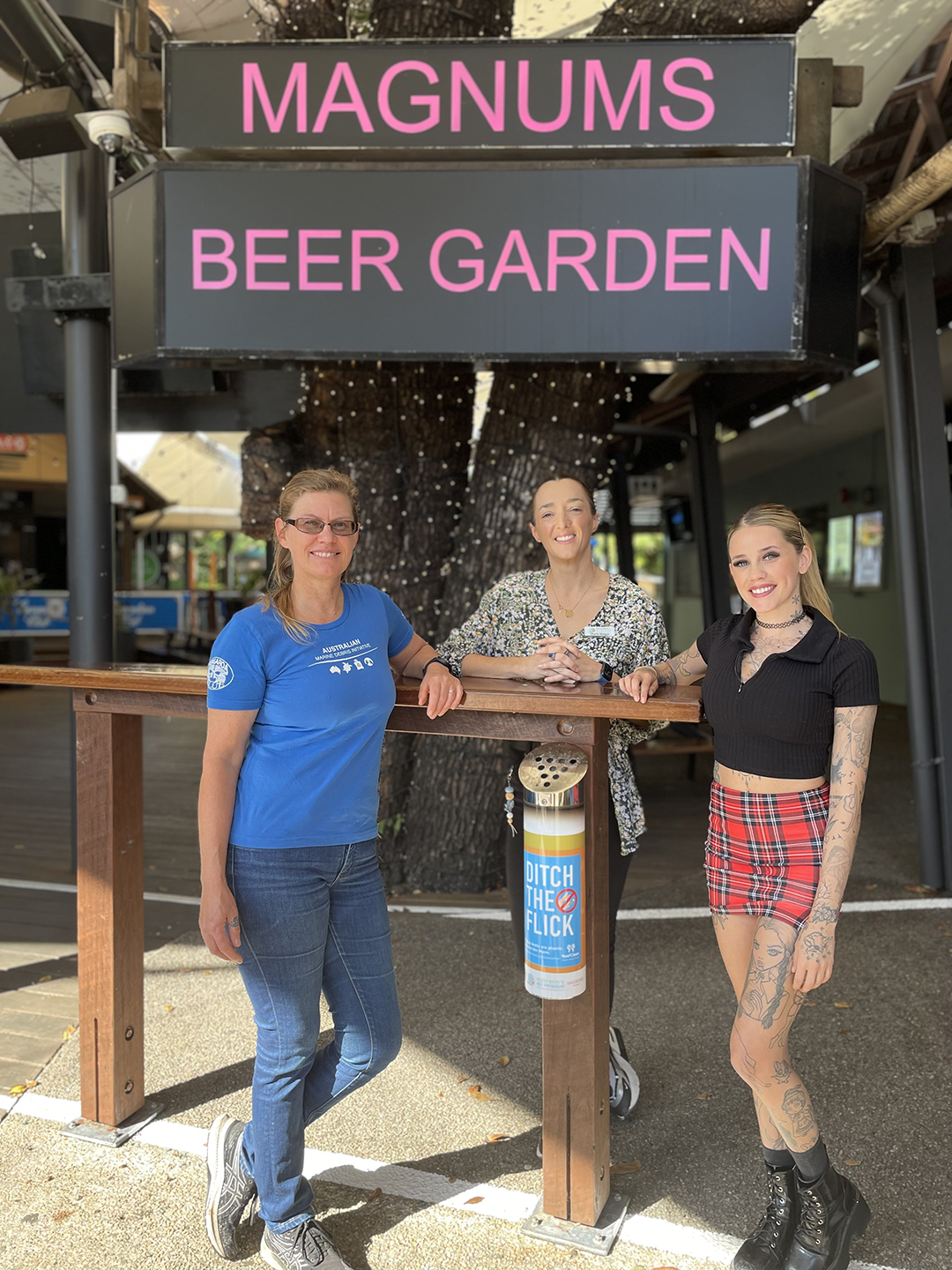 Tangaroa Blue CEO Heidi Tait, Healthy Rivers to Reef Chair Charlie Morgan, and Magnums Venue Manager Rebecca Cook standing next to a cigarette butt bin.