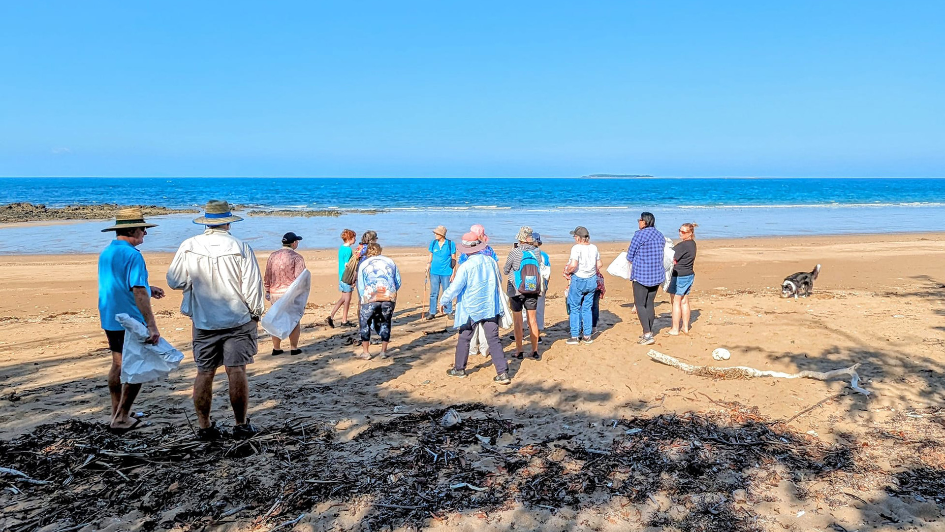 A group of people gathered on a beach.