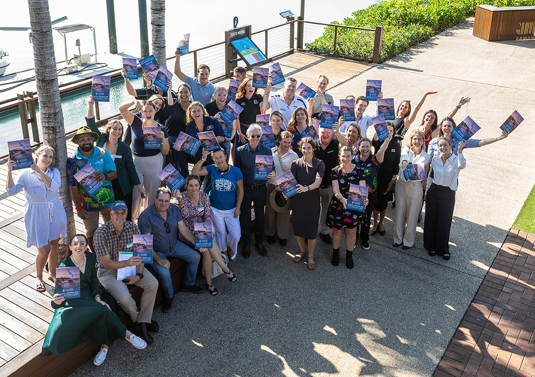 A group of people standing in front of a marina holding up posters.