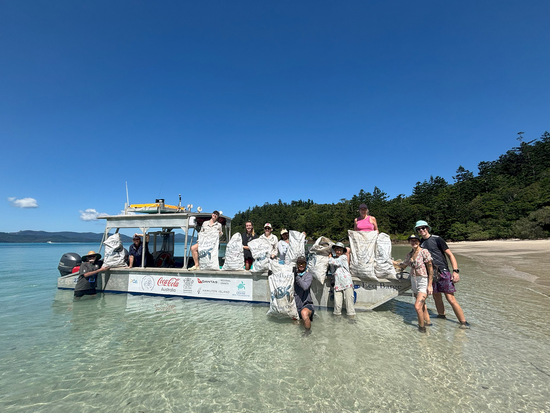 Eco Barge volunteers ready to depart a Whitsunday beach after collecting bags of marine debris.